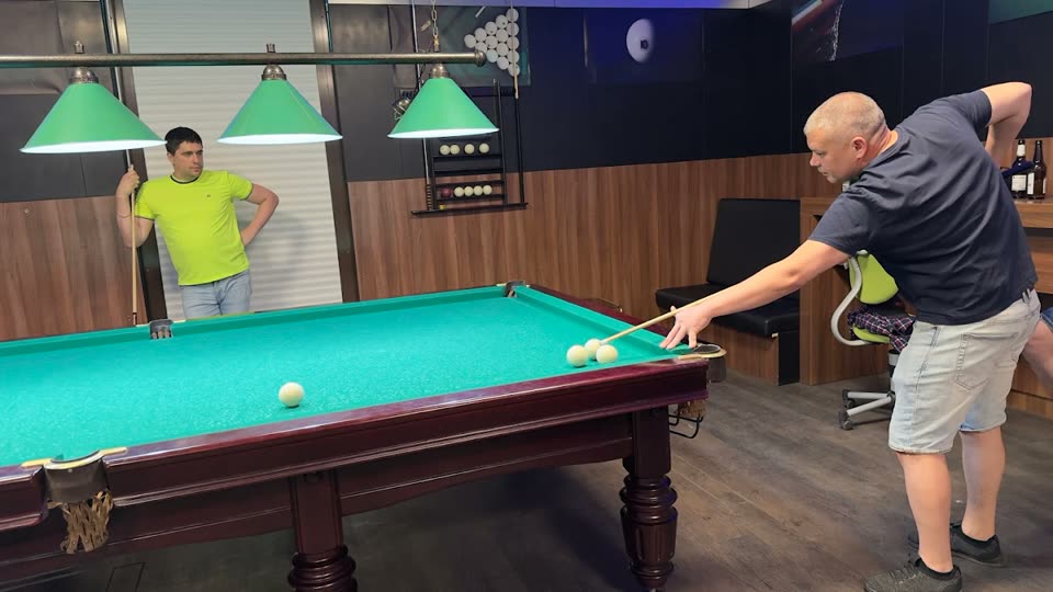 Два игрока у стола для русского бильярда с зелёным сукном в Billard O.
